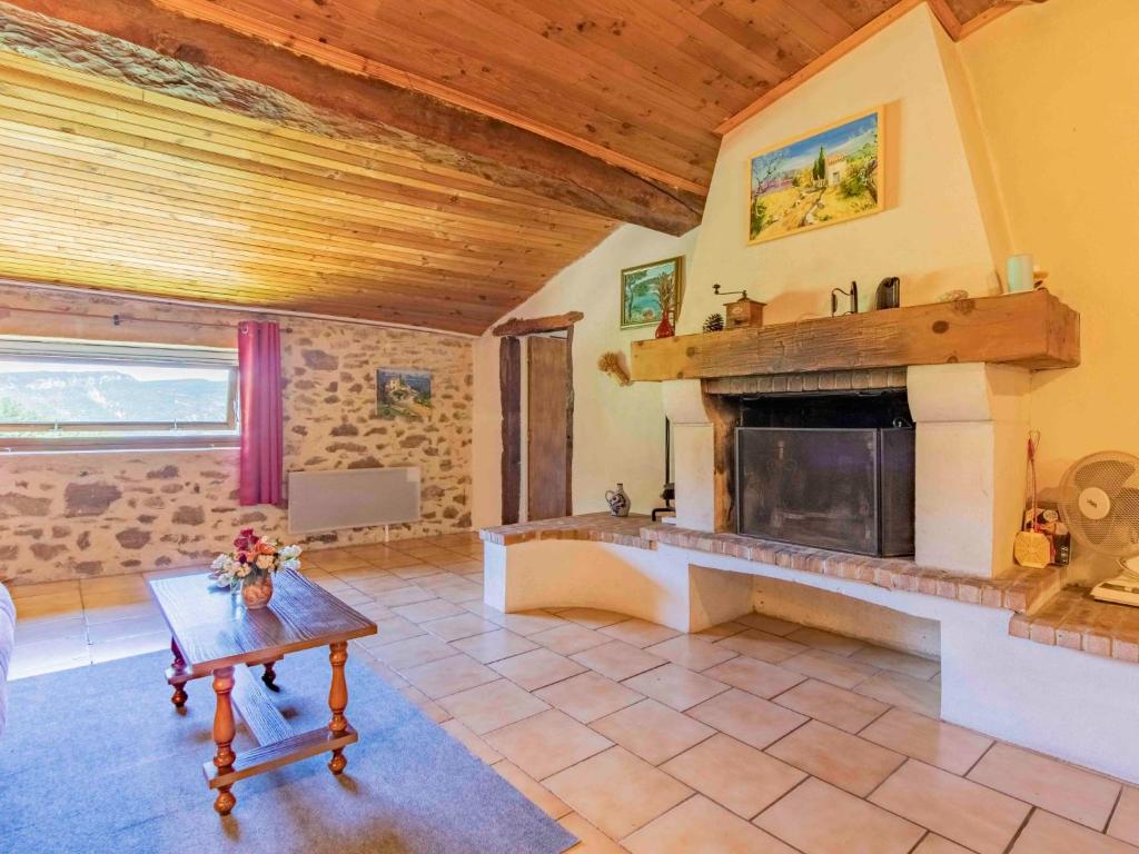 a living room with a fireplace and a table at Holiday Home Le Cèdre - RSB100 by Interhome in Roche-Saint-Secret