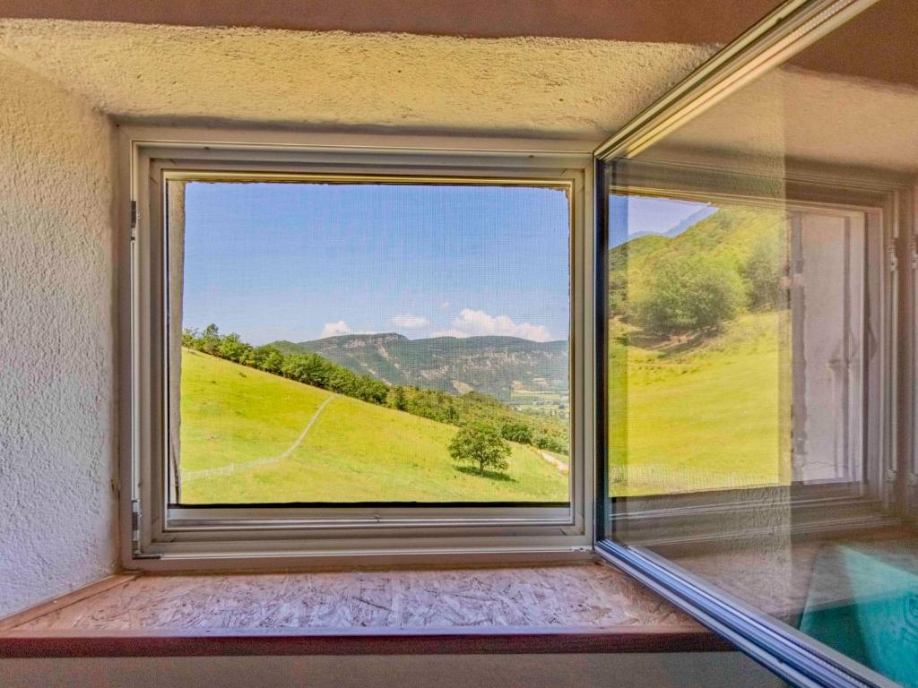 a window with a view of a green field at Holiday Home Le Cèdre - RSB100 by Interhome in Roche-Saint-Secret