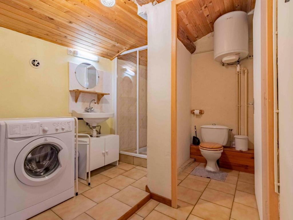 a bathroom with a washing machine and a toilet at Holiday Home Le Cèdre - RSB100 by Interhome in Roche-Saint-Secret