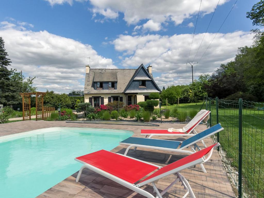 a pool with two lawn chairs and a house at Holiday Home Villa Rocuet by Interhome in Trégunc