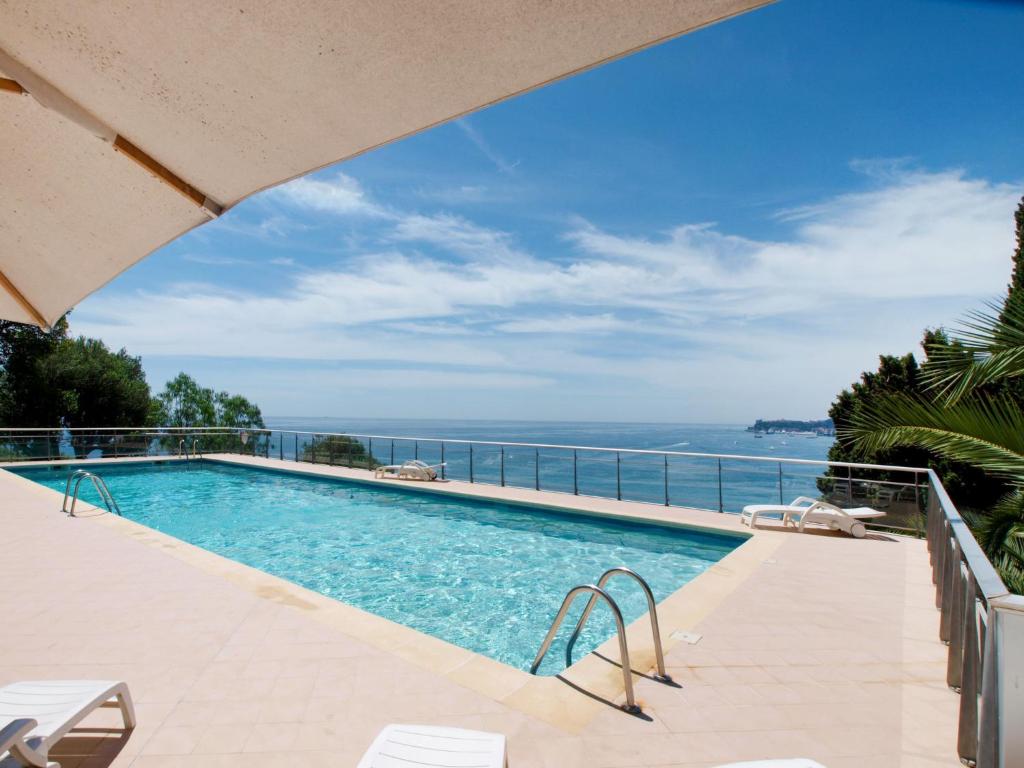 a swimming pool with a view of the ocean at Apartment Parc Massolin - ROQ110 by Interhome in Roquebrune-Cap-Martin
