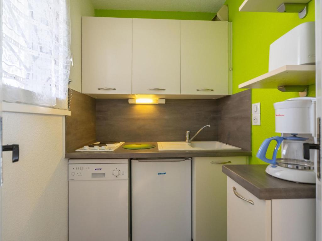 Elle comprend une petite cuisine avec des placards blancs et un évier. dans l&#39;établissement Apartment Les Balcons de l&#39;Atlantique-10 by Interhome, à Pontaillac