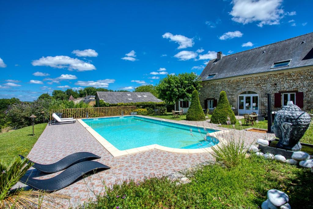 een zwembad in de tuin van een huis bij Hôtel A Jayac - Logis Hotels in Laval