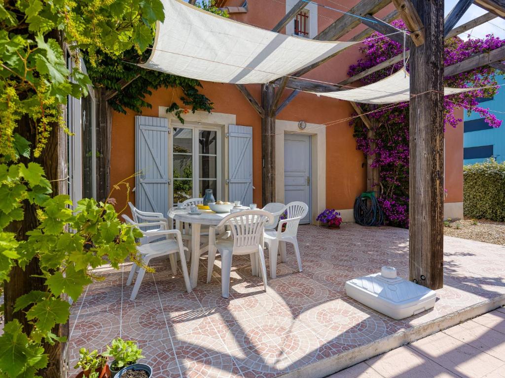 patio ze stołem, krzesłami i parasolem w obiekcie Holiday Home Les Grandes Bleues 2-1 by Interhome w mieście Narbonne-Plage