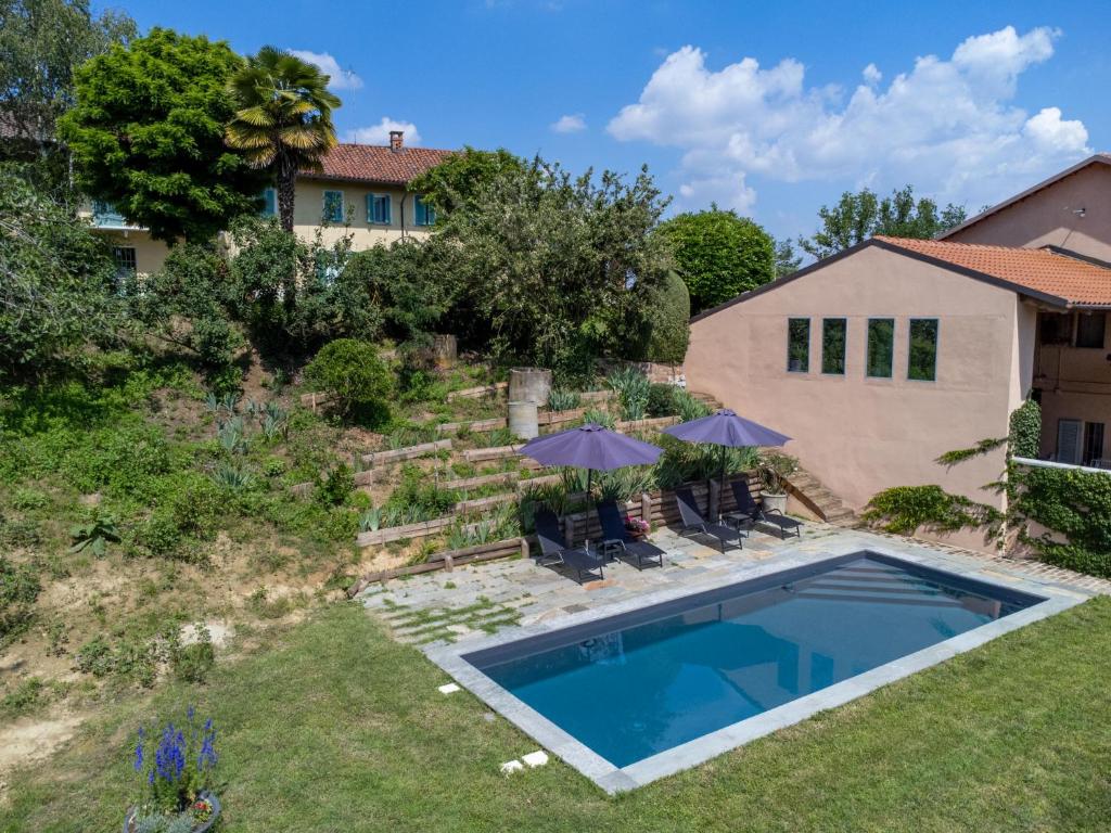 a backyard with a swimming pool and a house at Holiday Home La Rocchetta 1915-2 by Interhome in Cortandone