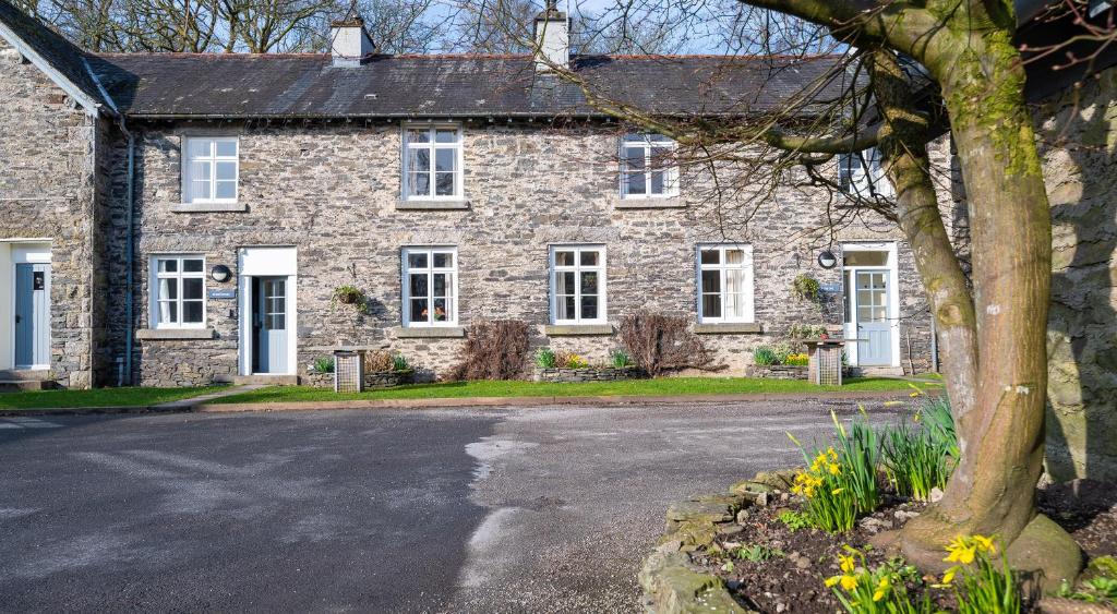 a stone house with a driveway in front of it at Greenhowes in Rusland