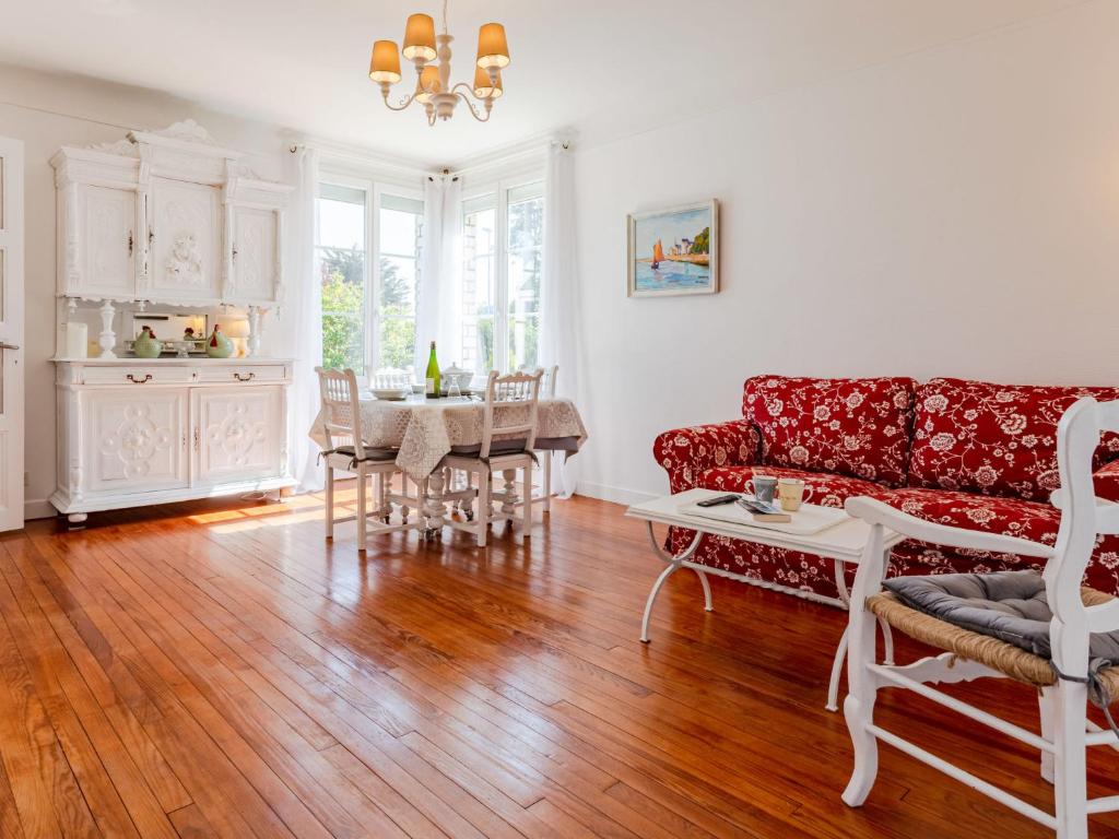 a living room with a red couch and a table at Holiday Home Le Colibri by Interhome in Cabourg