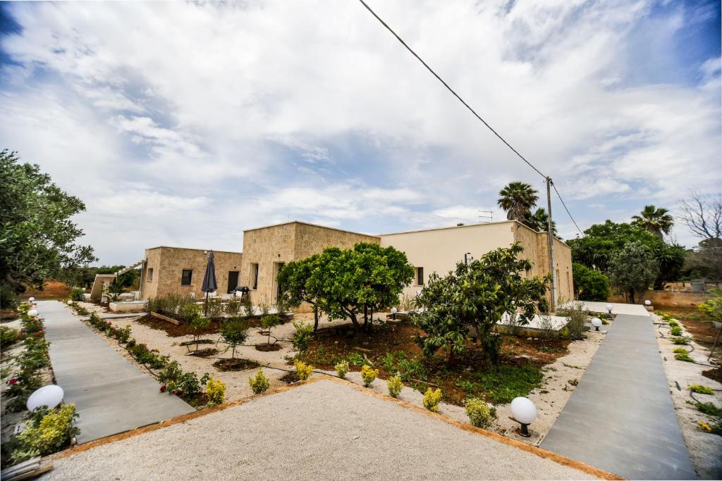 un edificio con un patio con árboles y plantas en Zeituna Lodge a Porto Cesareo, en Torre Lapillo