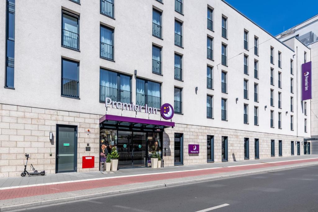 a white building with a store on a street at Premier Inn Düsseldorf City Centre in Düsseldorf