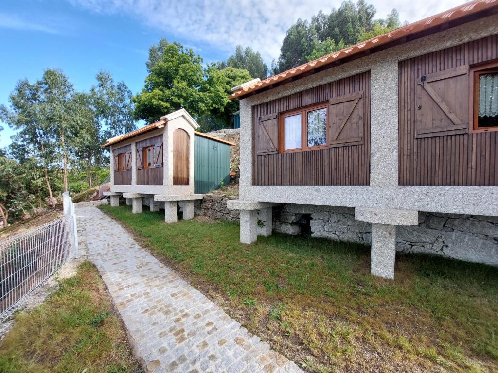 a row of cottages next to a fence at Canastro do Vidoeiro in Vieira do Minho