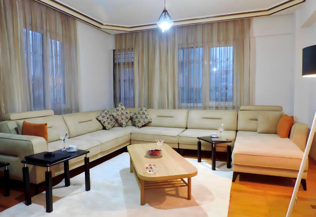 a living room with a couch and tables and windows at Central and Serene Flat with Balcony in Antalya in Antalya