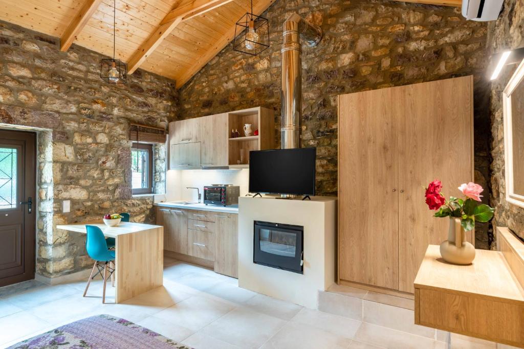 una cucina con parete in pietra e TV di Fotoula's stone studio 
