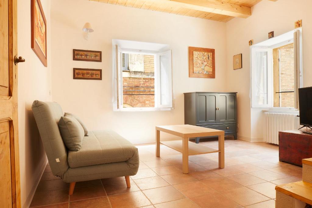 ein Wohnzimmer mit einem Stuhl und einem TV in der Unterkunft Medieval Experience near the Coast in Lapedona