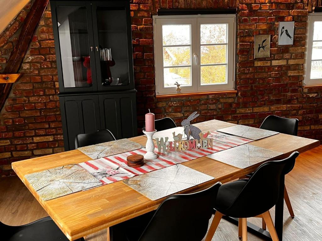 a wooden table in a room with a brick wall at Grosse-Schwalbe in Kabelhorst