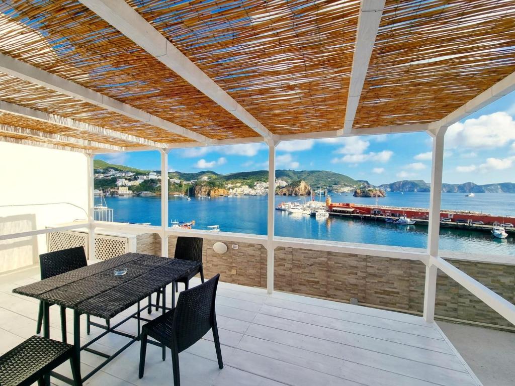een veranda met een tafel en stoelen en uitzicht op het water bij Maridea - La Darsena in Ponza