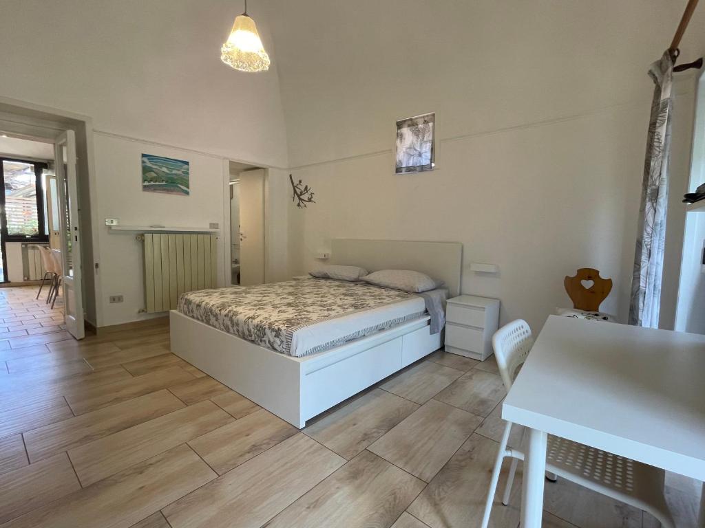 1 dormitorio con 1 cama y suelo de madera en La Coccinella, en Meta