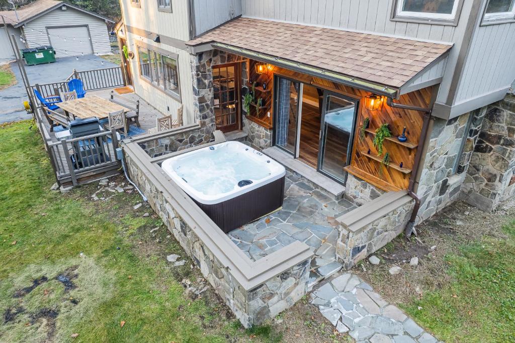 a building with a bath tub on a patio at Hot Tub, Firepit, 2 King Beds, Game Room, 200 +mbps in Hawley