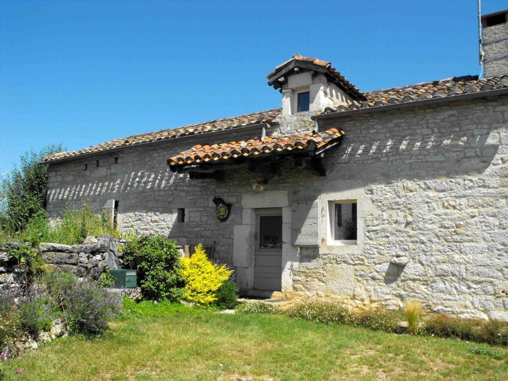 een oud stenen gebouw met een dak bij Gîte La Veyrie in Cazals