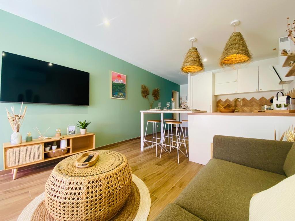 un salon avec un canapé et une table dans l'établissement LE BALI, Exceptionnel P3 avec piscine à 2 min des plages , parking, wifi et climatisation, à La Grande Motte