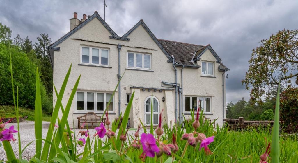 Hazelseat House في Sawrey: منزل أمامه زهور أرجوانية