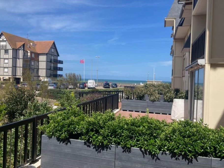 een balkon van een gebouw met planten en de oceaan bij TOP central Cabourg double terrasse 80m2 MER in Cabourg