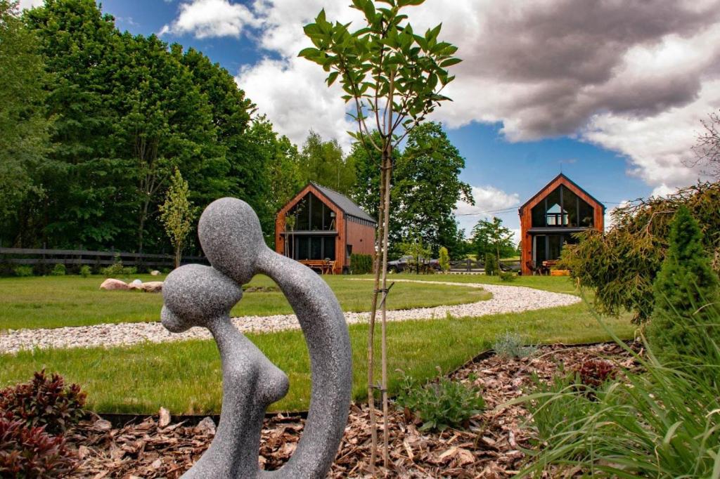 a metal sculpture of a person in a garden at Zielone Wrzosowisko in Świętajno