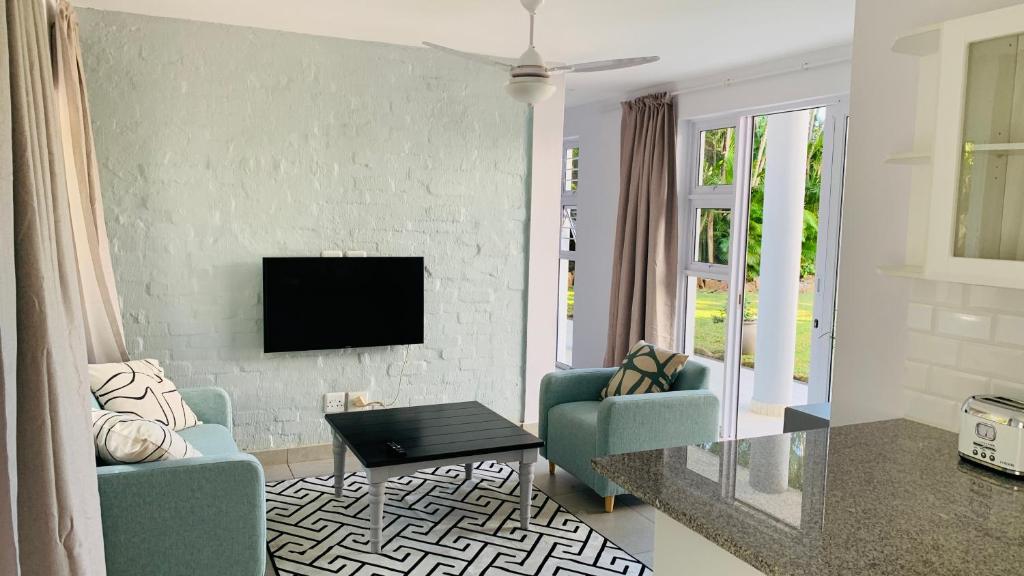 sala de estar con 2 sillas y TV en Stay in Style en Durban