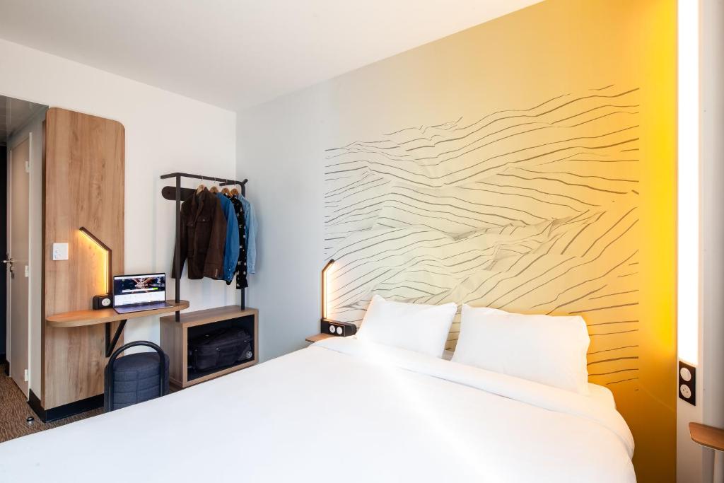 1 dormitorio con 1 cama y pared de madera en B&B HOTEL Cluses Sud, en Cluses