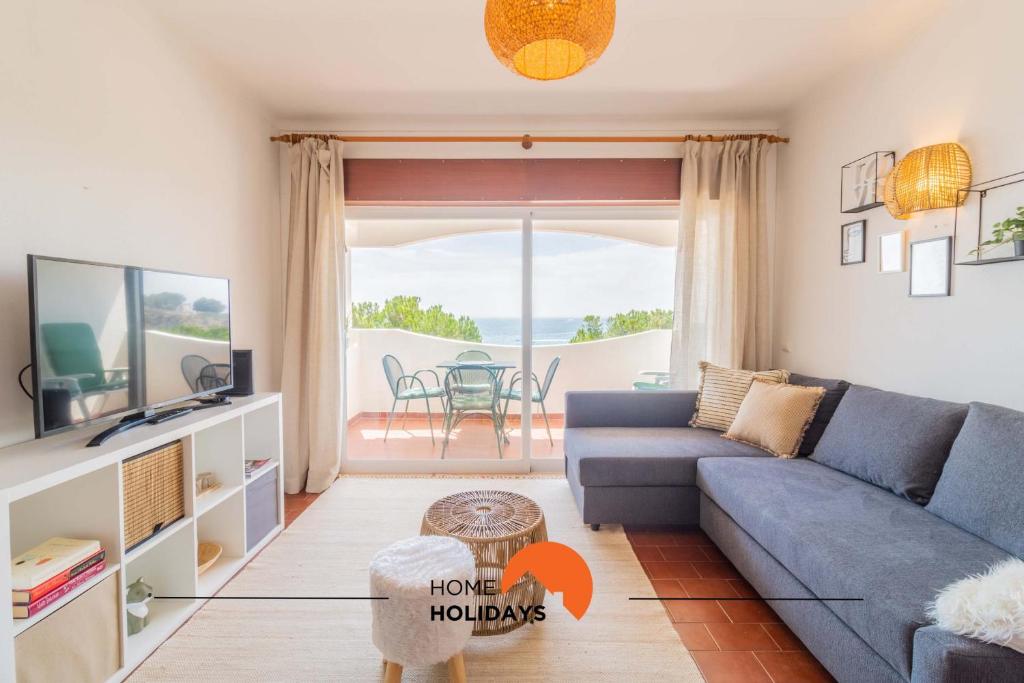 ein Wohnzimmer mit einer blauen Couch und einem Fernseher in der Unterkunft #103 Foxy V by Home Holidays in Páteo