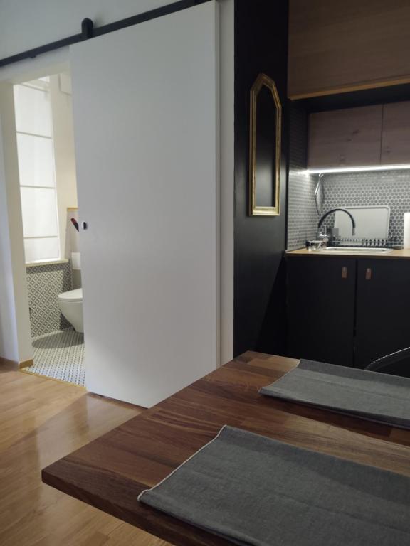 a kitchen with a wooden table and a bathroom at Apartment in Center in Kraków