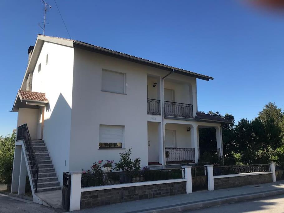 a white house with a staircase in front of it at Duplex em casa inteiro. 4 quartos. Bem localizada. in Bragança