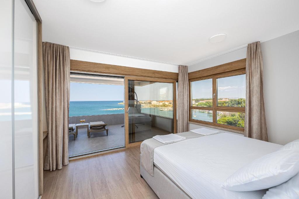 a bedroom with a bed and a view of the ocean at Salt&Soul Residence in Povljana