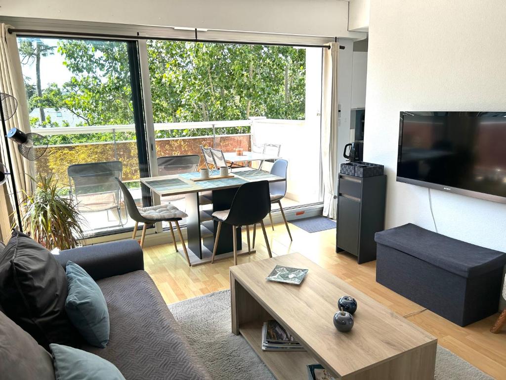 Televízia a/alebo spoločenská miestnosť v ubytovaní LA BAULE : T2 TRÈS PROCHE MER AU CALME