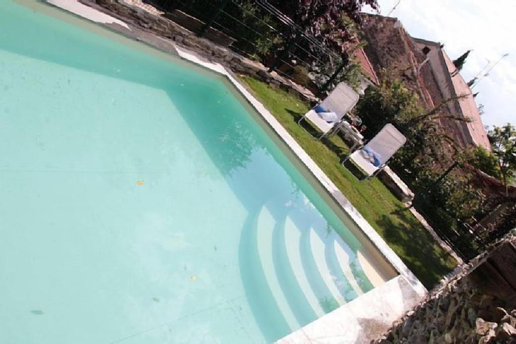 uma vista superior de uma piscina com duas cadeiras de jardim em Casa Rural Doña Catalina em Santa María la Real de Nieva