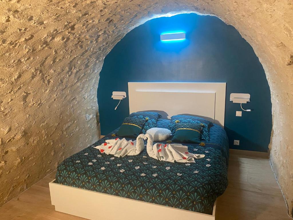 1 dormitorio con 1 cama en una pared de piedra en Trog'Love: Balnéo détente dans une troglodyte, en Tours