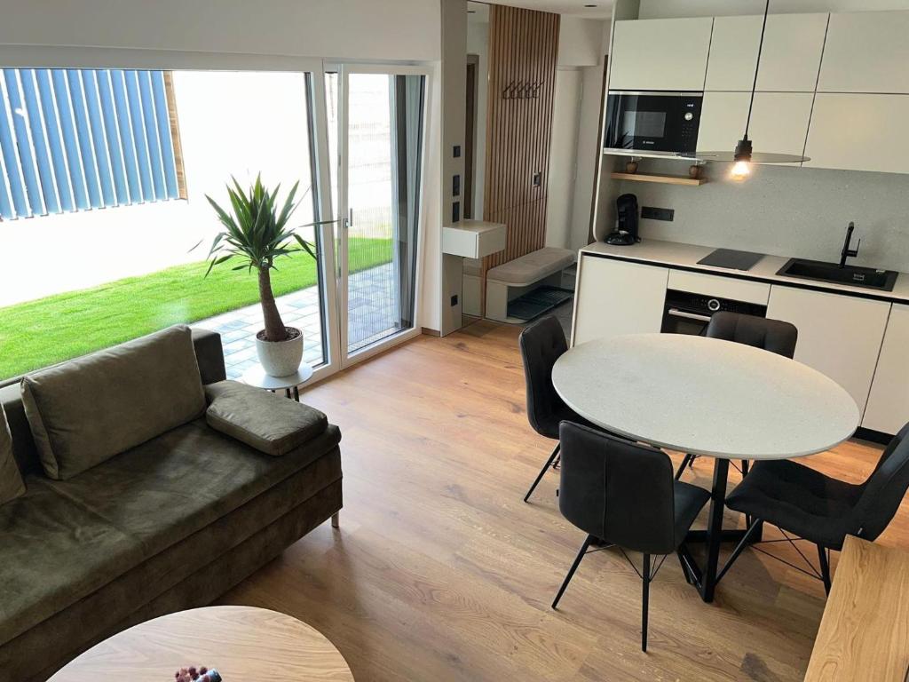 een woonkamer met een bank en een tafel en een keuken bij Apartment MAJA by Krone Travel Agency in Zell am See