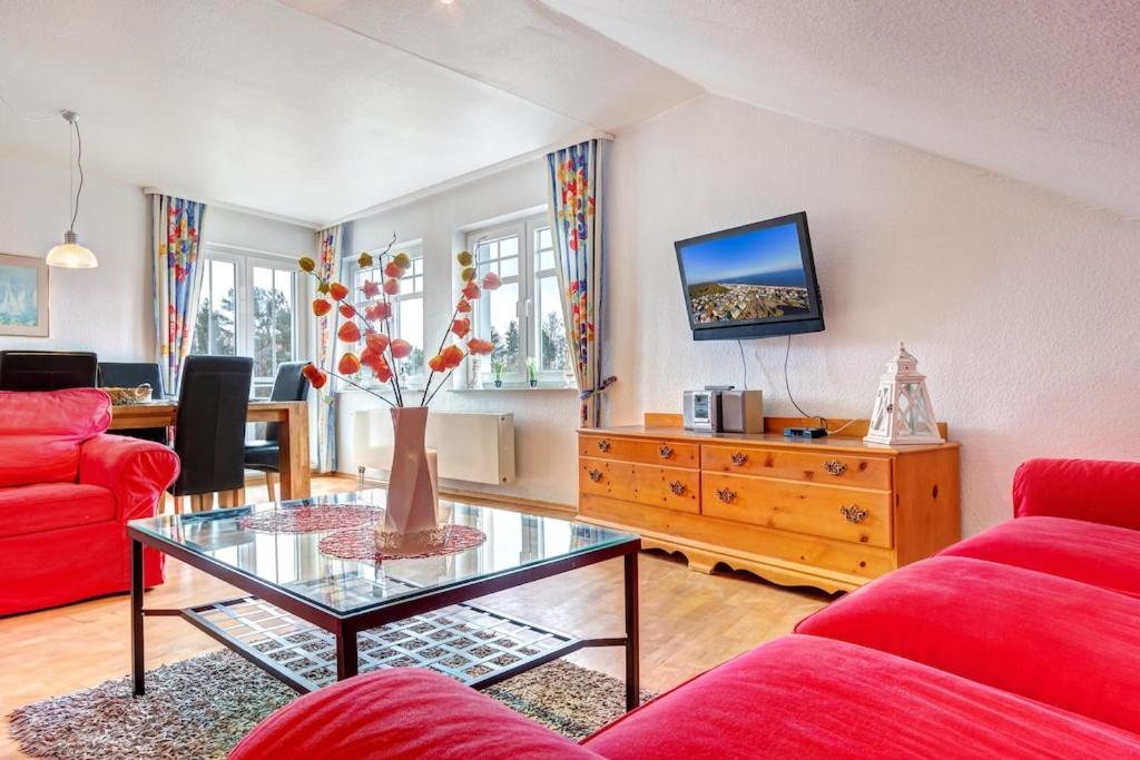 a living room with a red couch and a glass table at Strandnähe! Große schöne 3 Zimmer Ferienwohnung - 100 qm - für 6 Personen!! in Bansin