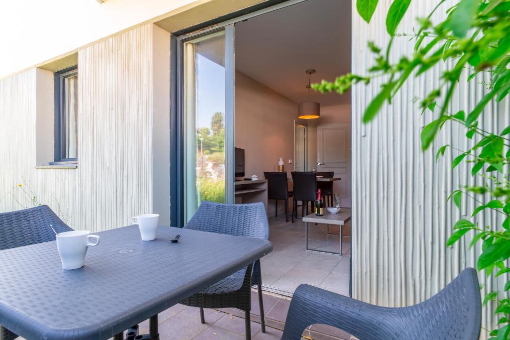 eine Terrasse mit einem Tisch und Stühlen sowie ein Esszimmer in der Unterkunft Les Thermes 427 - Appt avec piscine partagée in Concarneau