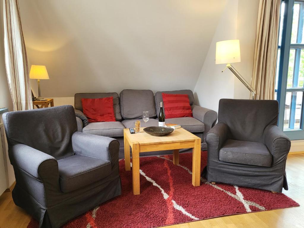 - un salon avec deux chaises et une table dans l'établissement Ferienwohnung "Emil", à Sankt Peter-Ording