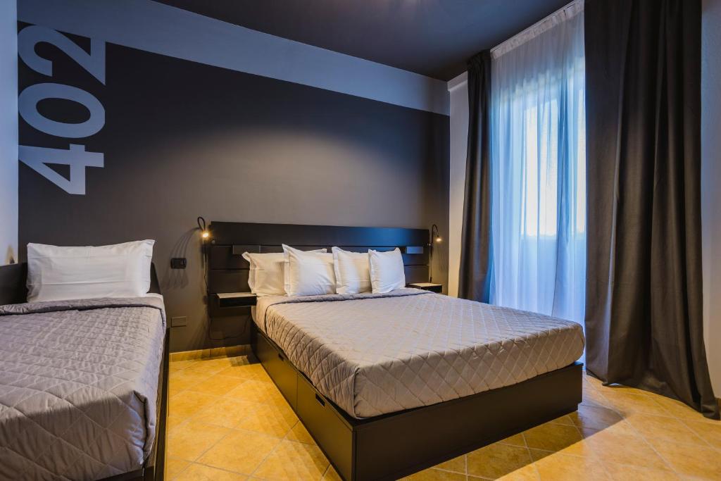 a hotel room with two beds and a window at Residence 9 Line in Milano Marittima