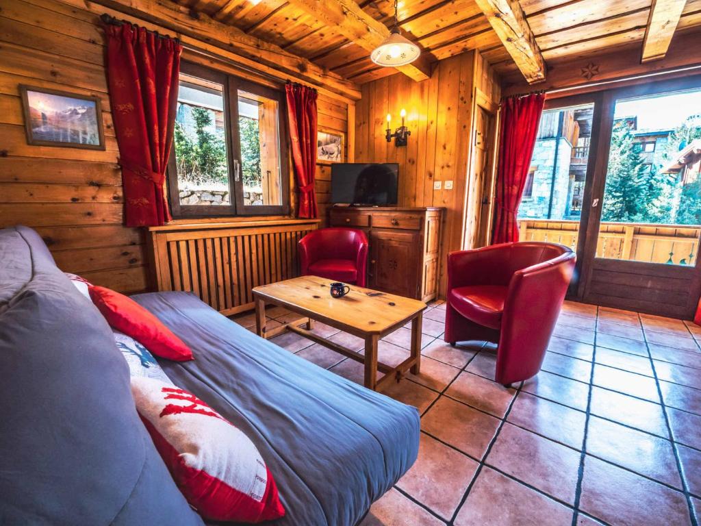 salon z łóżkiem, stołem i krzesłami w obiekcie Appartement rénové dans chalet savoyard - proche des pistes, balcon, animaux admis - FR-1-502-355 w mieście Tignes