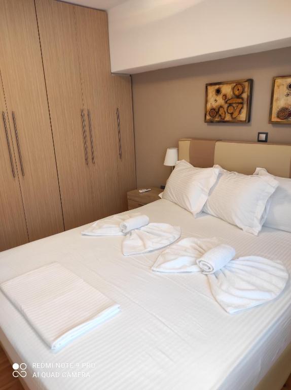 Astradeni luxury apartments Vootis في Páloi: غرفة نوم عليها سرير وفوط