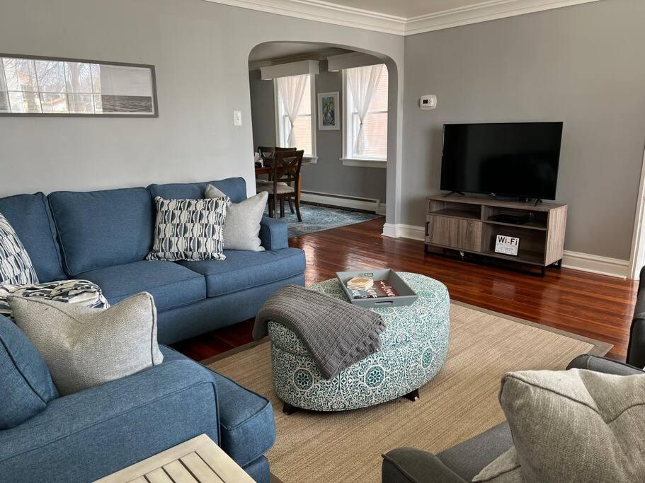a living room with a blue couch and a tv at Spacious & Peaceful Home in the heart of Sheboygan in Sheboygan