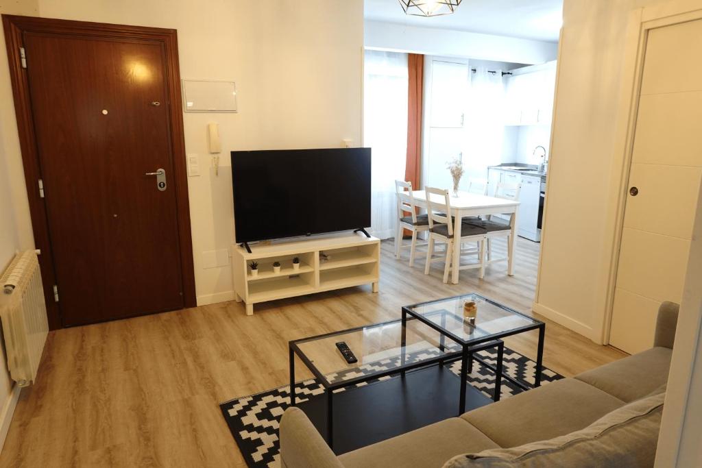 a living room with a couch and a television at Vacare centro de Santander in Santander