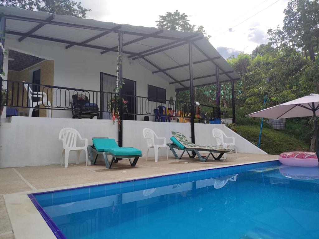 d'une terrasse avec des chaises et une table à côté de la piscine. dans l'établissement CASA BLANCA EN LA VEGA, à La Vega