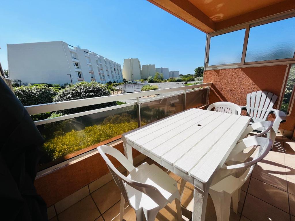 a white table and chairs on a balcony at Standing et océan à 50m, appartement de l'oasis in Saint-Jean-de-Monts