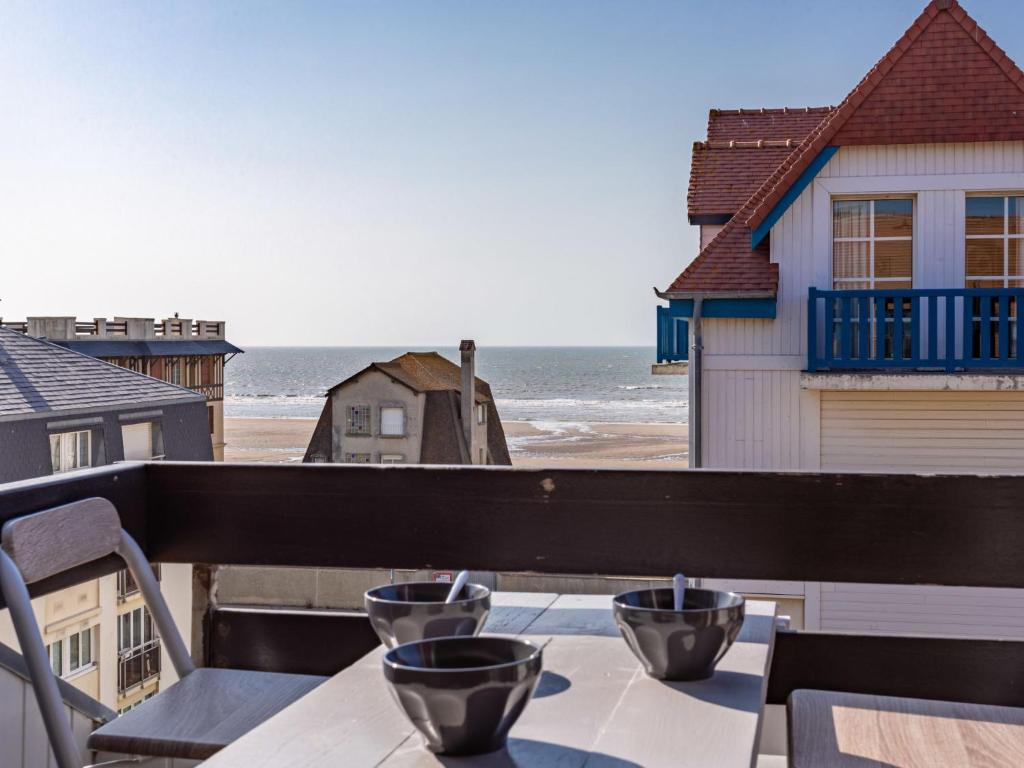 a table on a balcony with a view of the ocean at Apartment Le Grand Cap-15 by Interhome in Villers-sur-Mer