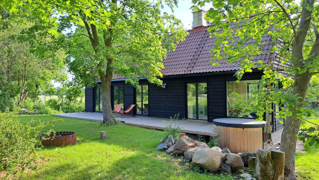 Kiigemäe maamaja : منزل أسود صغير مع شرفة وساحة