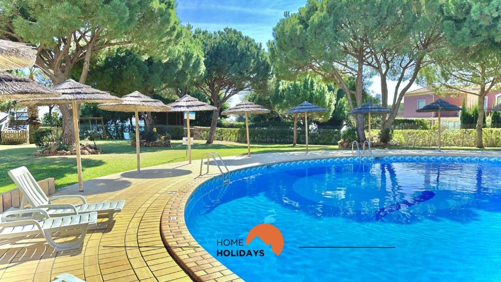 una piscina con sillas y sombrillas en un patio en #101 Kid Friendly with Pool, Private Park, 400 mts Beach en Albufeira