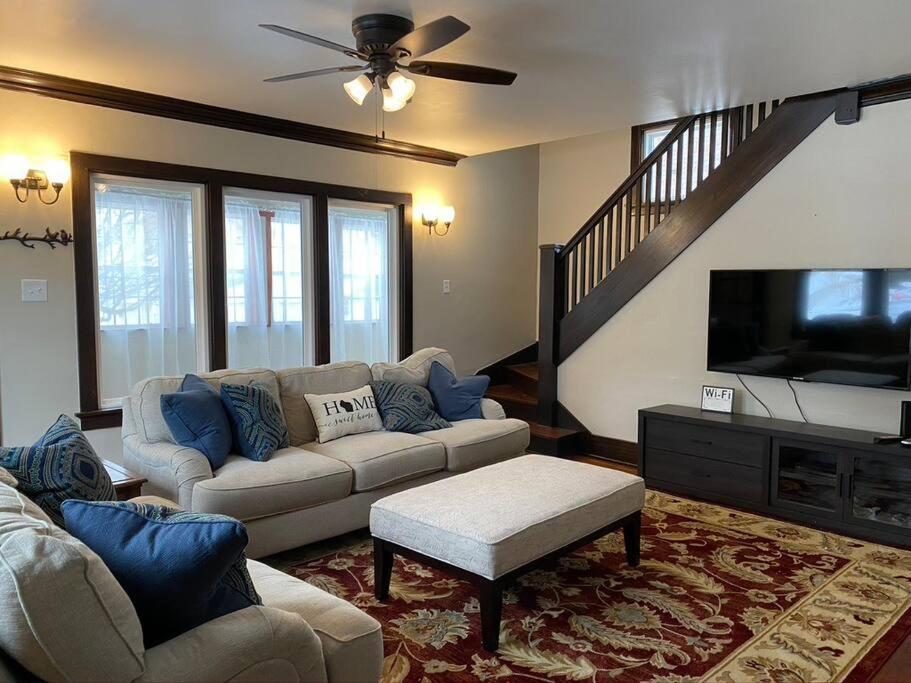 a living room with a couch and a flat screen tv at Serene Home One Block From Lake Michigan in Sheboygan